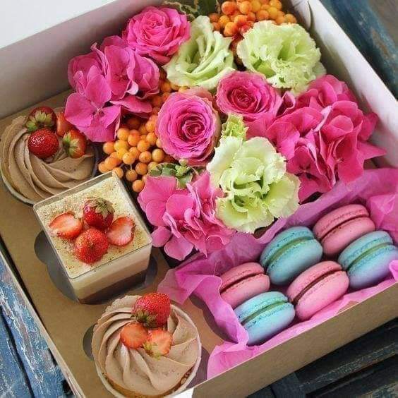 Dessert gift box with roses, macarons, chocolate strawberries, and small cakes in pink compartments