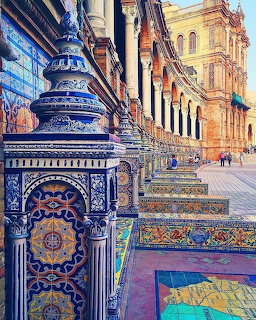 Colorful ceramic tile columns and benches at Plaza de España in Seville with ornate architecture