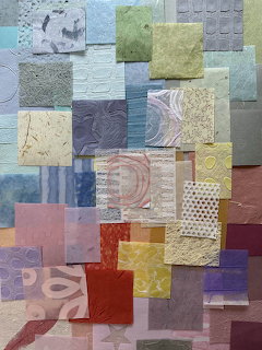 Overlapping squares of colorful textured mulberry paper with various embossed patterns in blues, greens, yellows, and reds