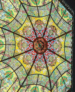Art Nouveau stained glass dome with colorful geometric patterns and floral designs radiating from ornate center