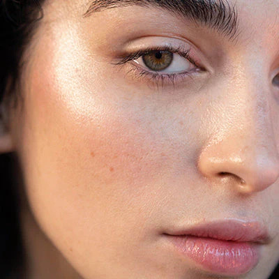 Close-up portrait of woman with brown eyes and natural makeup showing glowing skin