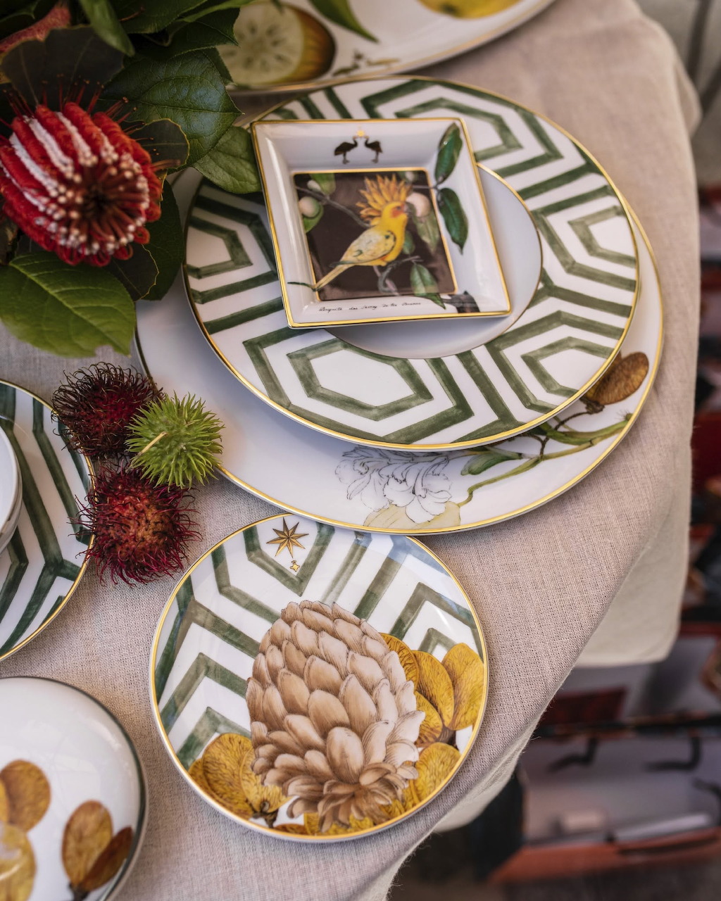 Autumn table setting with patterned plates, chestnuts, leaves, and seasonal food accents
