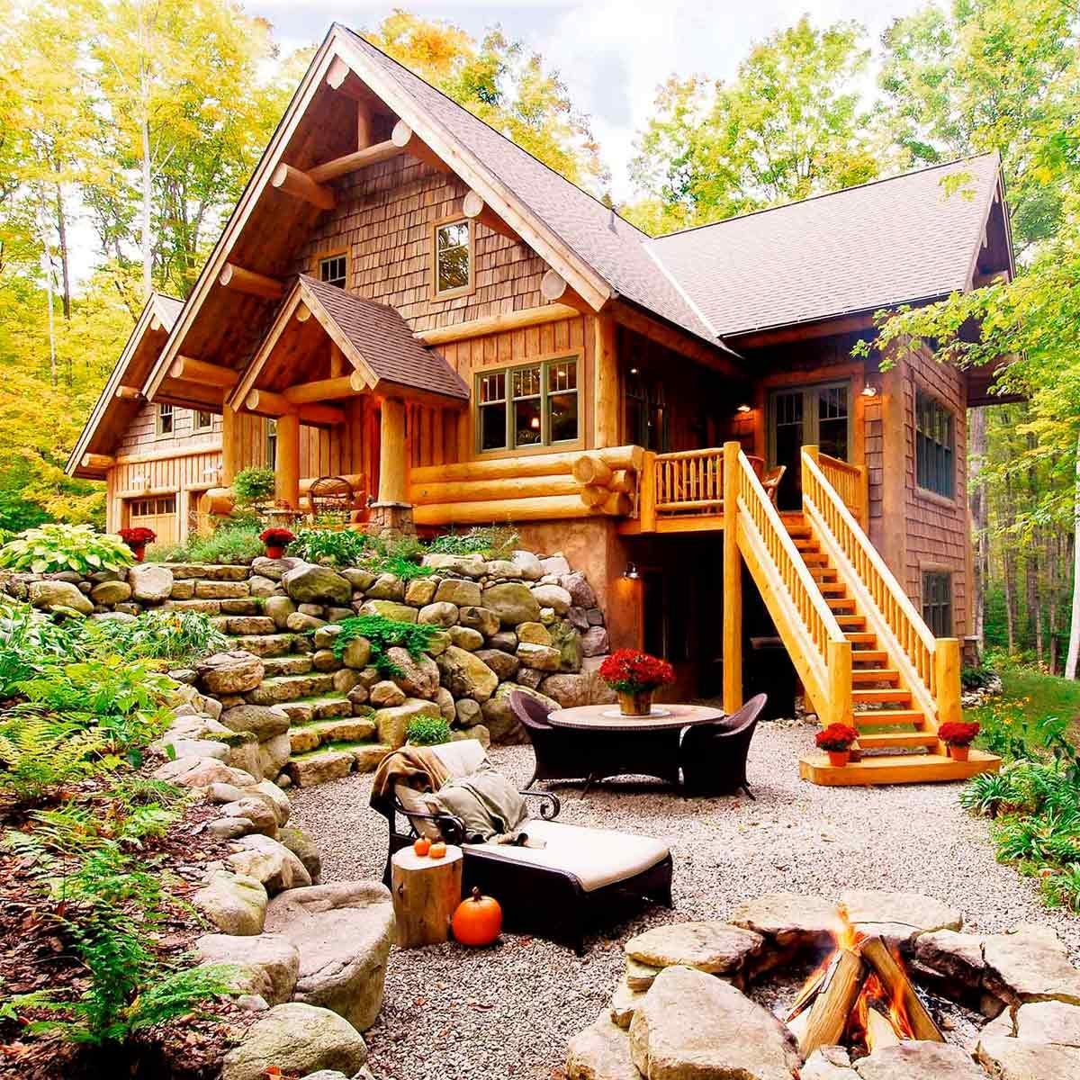 Log cabin with stone pathway and firepit in wooded setting