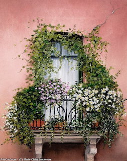 Balcony on a pink building covered in climbing ivy and white and purple flowers with a curtained window above.