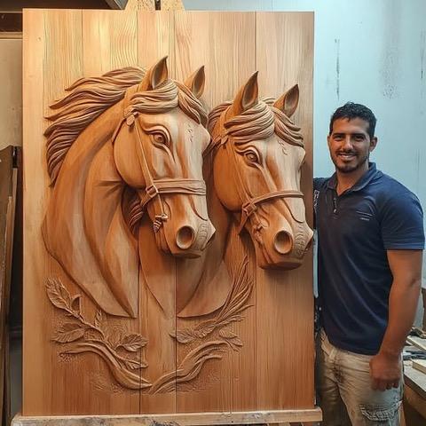 Man standing next to a carved wooden panel with two horse heads in relief