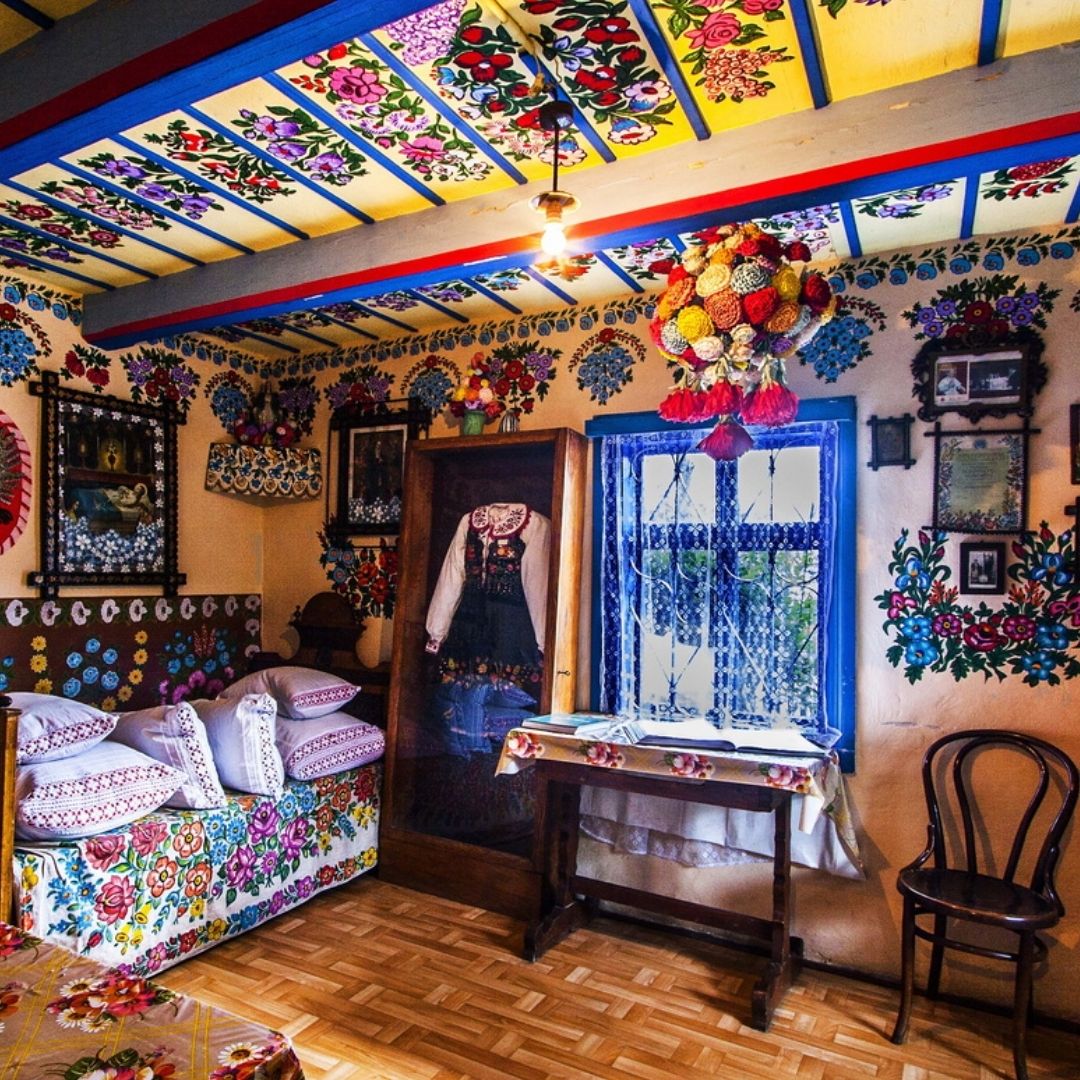 Bright traditional Polish cottage interior with painted floral ceiling and colorful folk decorations