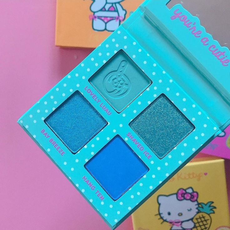 Turquoise makeup palette with four blue shades on a pink background