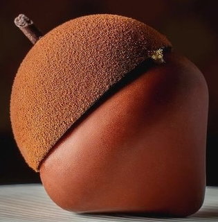 Chocolate dessert shaped like an acorn with textured cap and smooth glossy finish