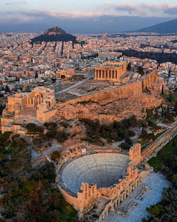 Aerial view of Athens Acropolis with Parthenon temple at sunset, ancient Greek ruins on rocky hill above modern city
