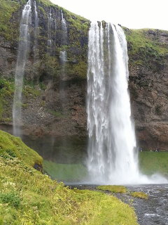 Seljalandsfoss waterfall in Iceland with water cascading down rocky cliff into pool below