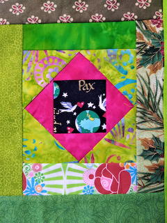 Colorful fabric quilt block with diamond center and floral patchwork border in green, pink, and bright patterns