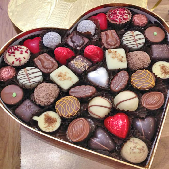 Heart-shaped box of assorted chocolates and truffles viewed from above