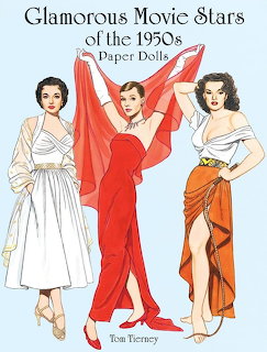 Vintage paper dolls cover with three glamorous women in 1950s dresses on a light blue background