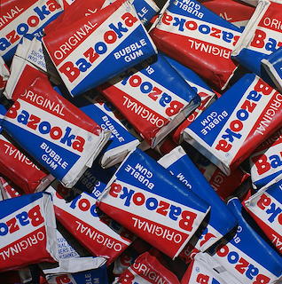 Many Bazooka bubble gum packages scattered together showing red, white and blue packaging