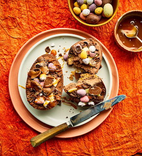 Chocolate cookie pizzas decorated with colorful Easter candy and mini eggs on a white plate