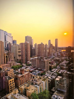 Golden sunset over Manhattan skyline with tall buildings and residential towers