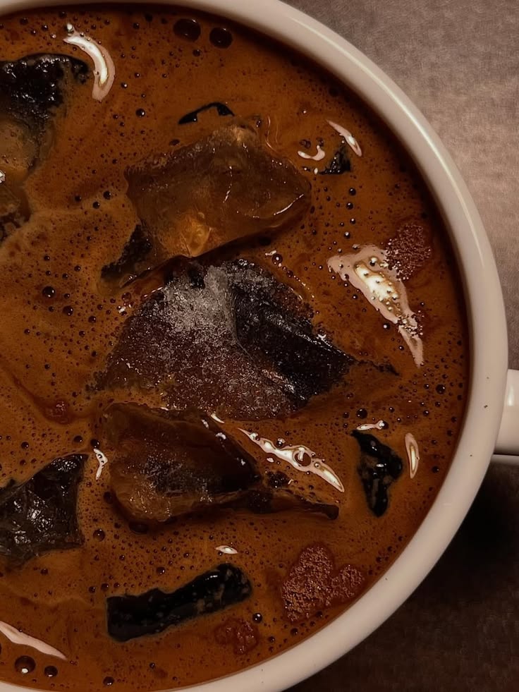 Overhead view of iced coffee with ice cubes in white cup