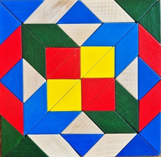 Colorful square wooden mosaic with geometric shapes in red, blue, green, yellow, and natural wood