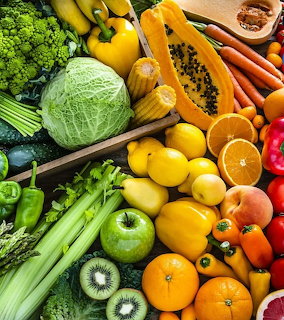 Vibrant array of fresh fruits and vegetables including peppers, citrus, kiwis, cabbage, and leafy greens
