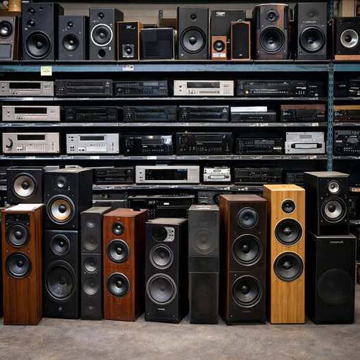 Vintage stereo components and speakers arranged on shelves and the floor