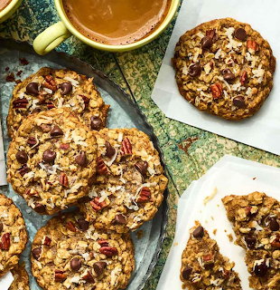Overhead view of chunky cookies with chocolate chips and nuts next to a cup of tea
