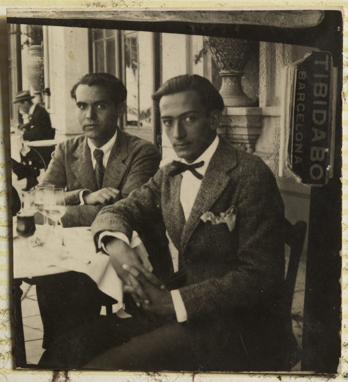 Black and white photo of two men in suits sitting at a table