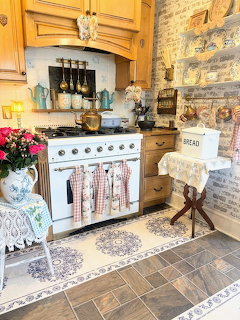 Vintage country kitchen with yellow cabinets, white stove, brick wall, and decorative tile floor