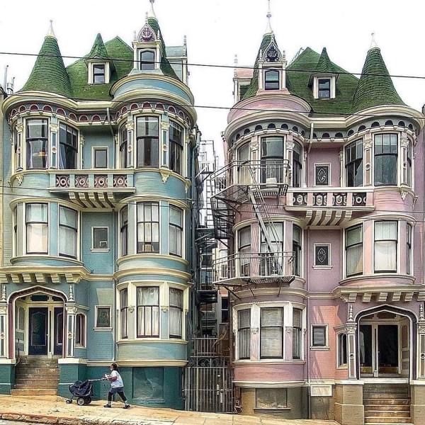 Two ornate Victorian houses, one green and one pink, with bay windows and turrets