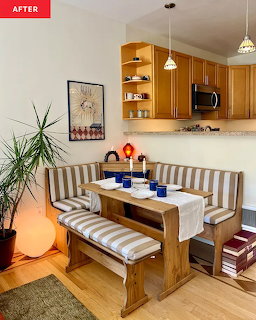 Kitchen dining nook with striped cushioned bench seating, wooden table, blue dishes, and wooden cabinets