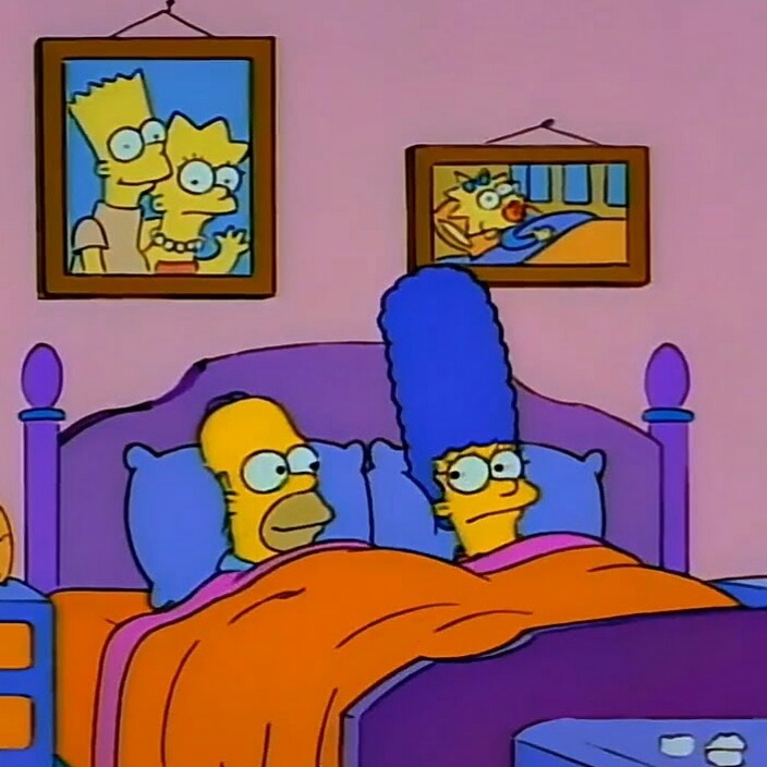 Homer and Marge Simpson in bed with family portraits on wall
