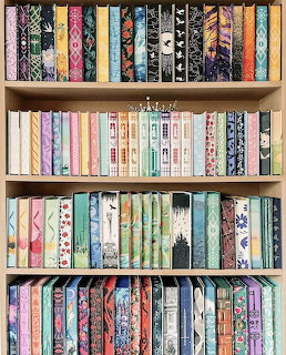 Four shelves of colorful books arranged vertically, displaying decorative spines with patterns and text