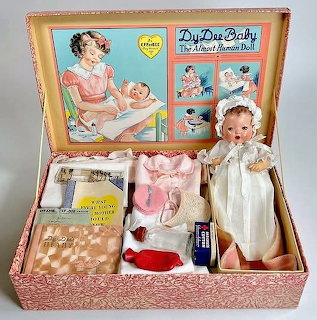 Vintage Dy-Dee Baby doll in pink suitcase with vintage clothing and accessories