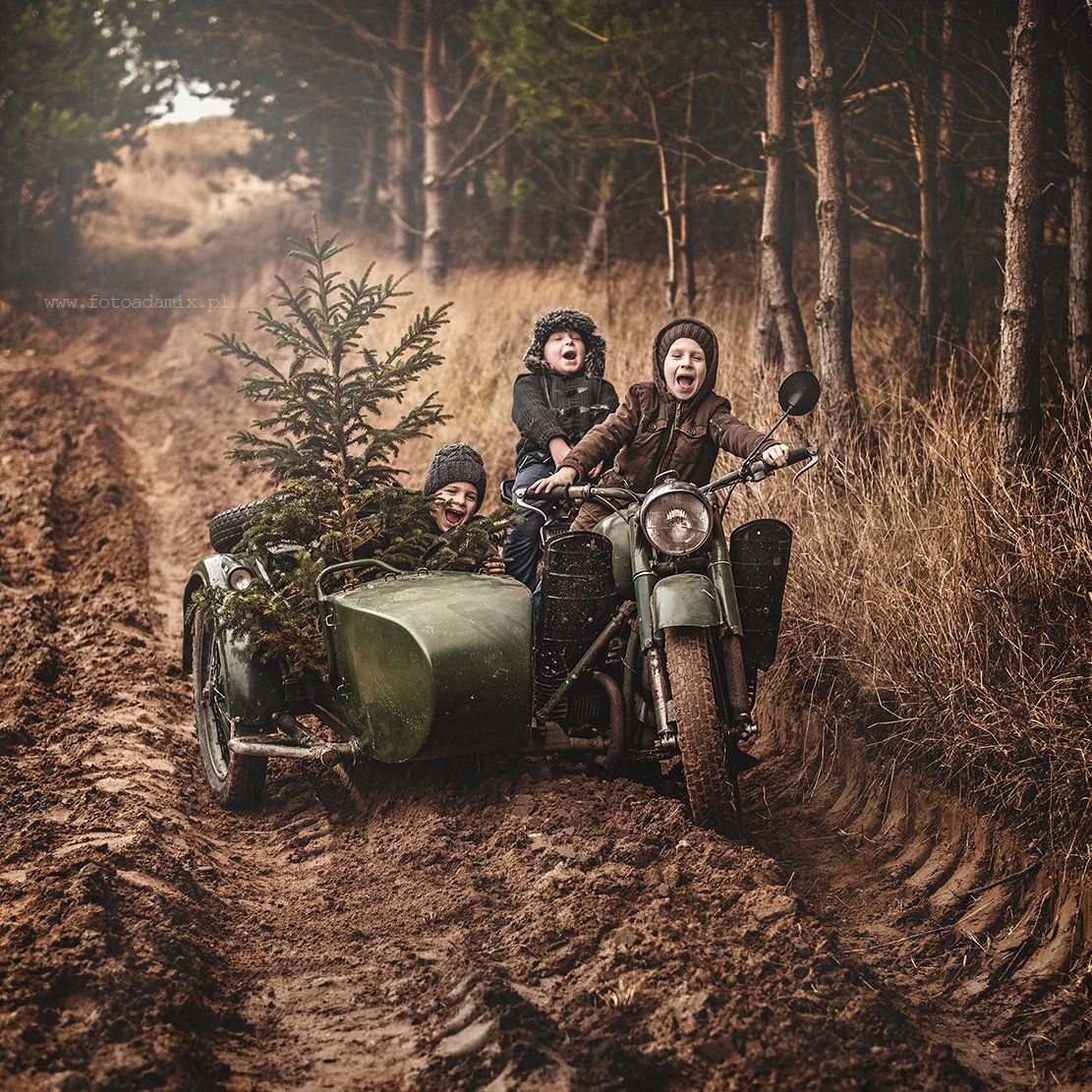Three riders on a vintage motorcycle with sidecar on a muddy forest road