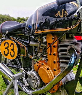 Close-up of a vintage AJS 7R motorcycle engine and tank with number 33