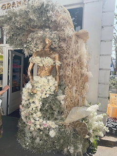 Large decorative mermaid sculpture made entirely of white flowers and dried botanical materials