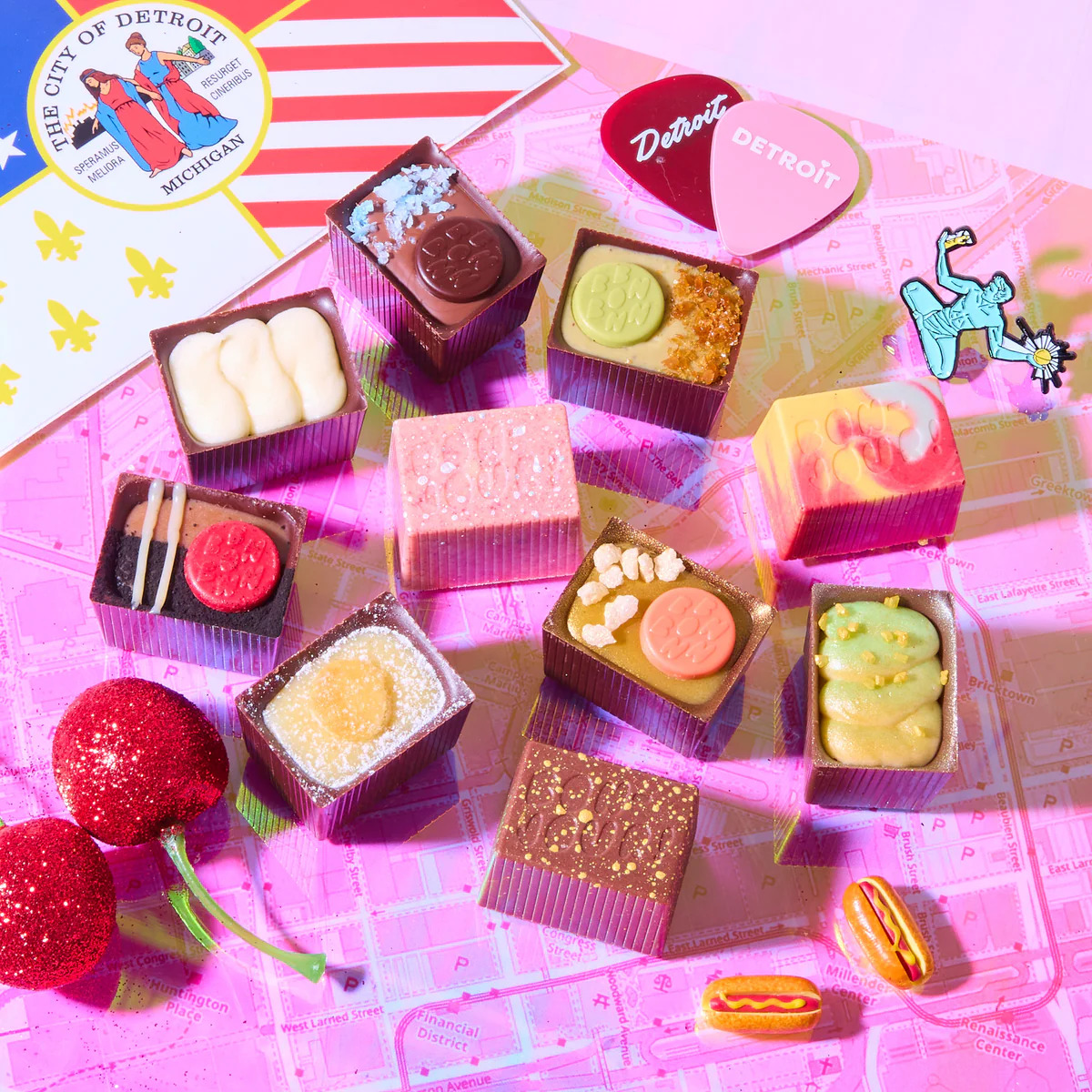 Colorful assorted chocolate bonbons with decorative toppings on pink plaid background