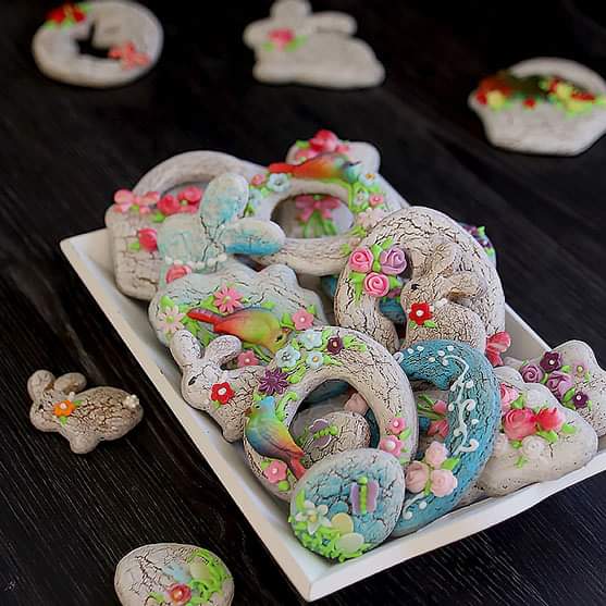 Ornate number 30 cake decorated with pastel icing, roses, and colorful details alongside matching cookies