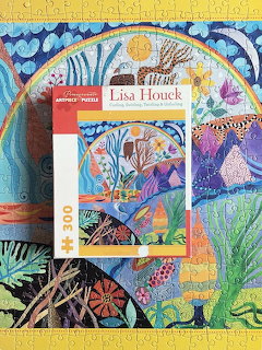 Puzzle box with Lisa Houck artwork on a colorful abstract patterned background