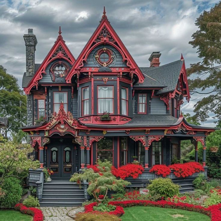Victorian Gothic house with red decorative trim, pointed arches, tower, porch, and landscaped garden under cloudy sky