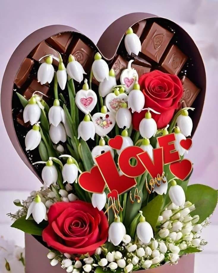 Red roses and white snowdrops arranged with heart-shaped chocolate box and love message decoration