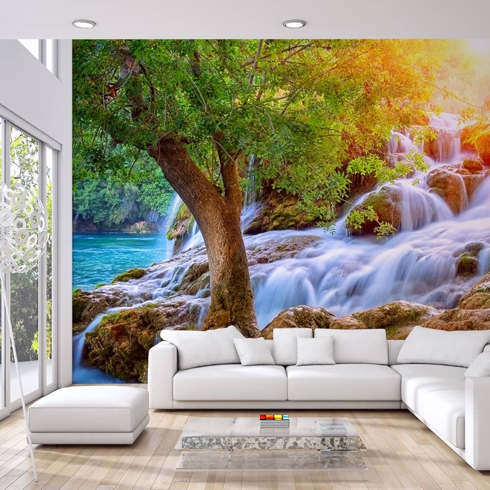 Flowing waterfall cascading over rocks beside a green tree with sunlight filtering through forest foliage