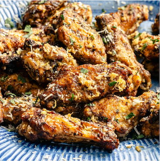 Crispy herb-seasoned chicken wings piled on a blue patterned plate