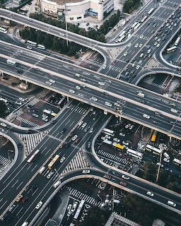 Aerial view of a busy multi-level highway interchange with cars and curved ramps