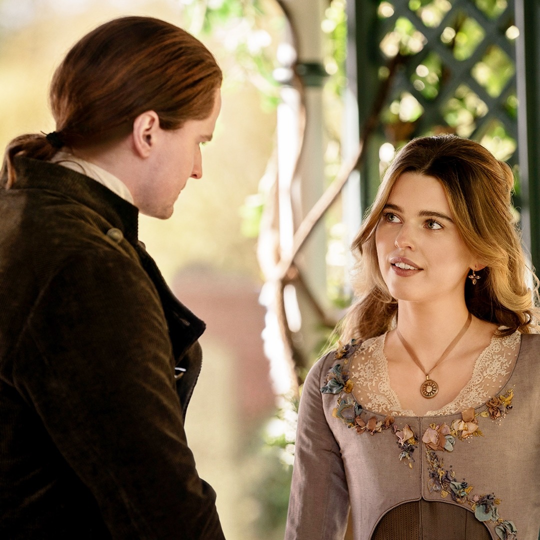 Two people in 18th century period costumes having a conversation indoors with soft natural lighting