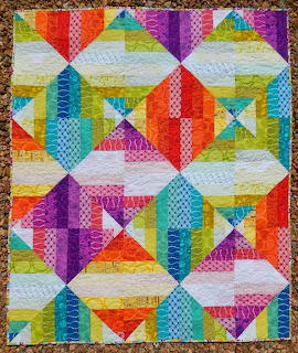 Colorful geometric patchwork quilt with diamond and triangle patterns