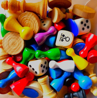 Close-up of colorful wooden game pieces, pawns, chess pieces, and dice