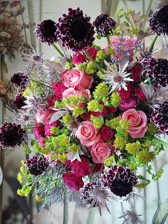 Colorful bouquet with pink roses, dark purple dahlias, white flowers, and bright green accents