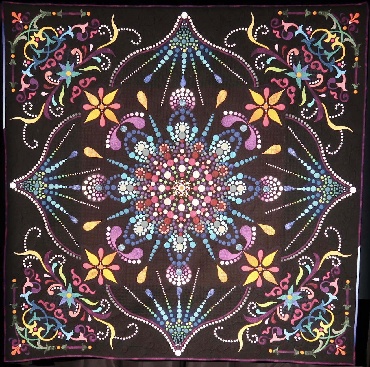 Colorful mandala dot painting with symmetrical floral design and decorative corners on black background