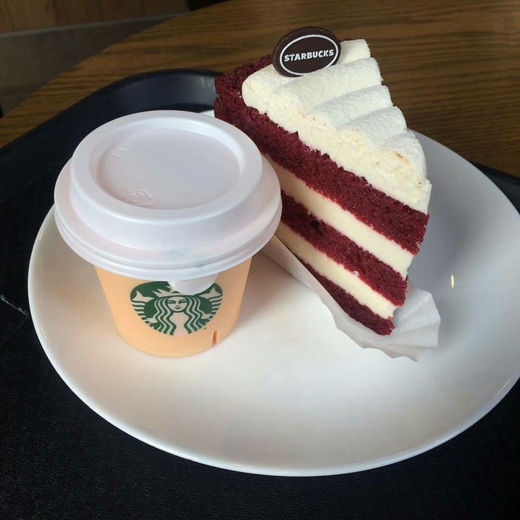 Takeaway coffee cup and slice of red velvet cake on a white plate