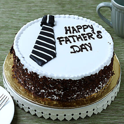 Black forest cake decorated with white frosting, fondant necktie, and Father's Day message